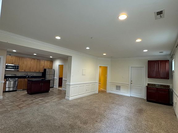 View of kitchen, living area and wine closet from front door.