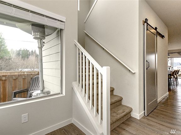 What the sellers loved about this house is all the natural light that floods in from the big windows and all the transit windows that were positioned to let light in and extra views upstairs! UPGRADE: Barn door slides easily for extra storage under staircase.