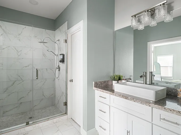 Private ensuite bathroom with a walk-in glass shower and dual shower heads.