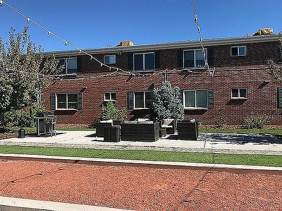 Enjoy outdoor living in this charming apartment setting, complete with cozy seating and beautiful landscaping.