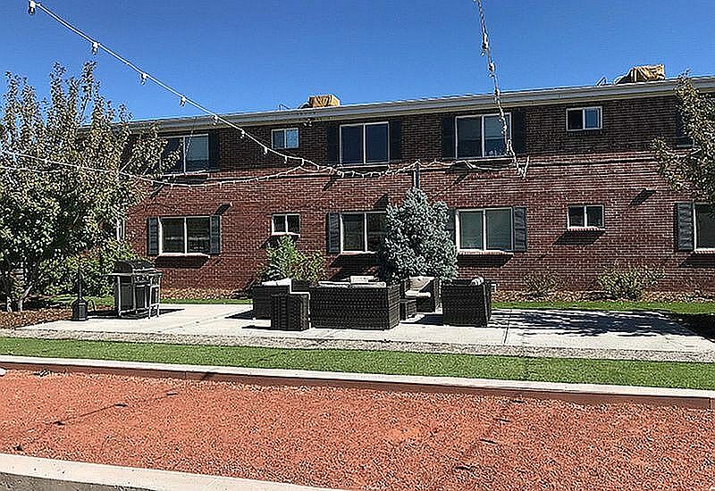 Enjoy outdoor living in this charming apartment setting, complete with cozy seating and beautiful landscaping.