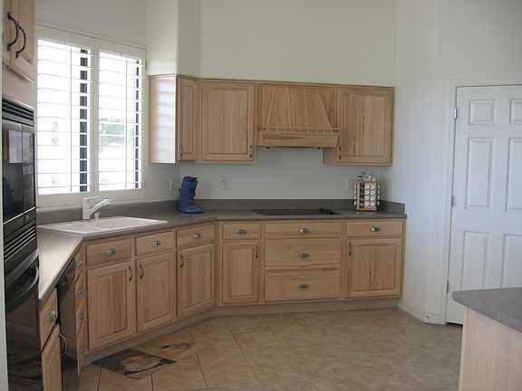 Bright kitchen opens to family room and breakfast area. Window views patio and golf course.