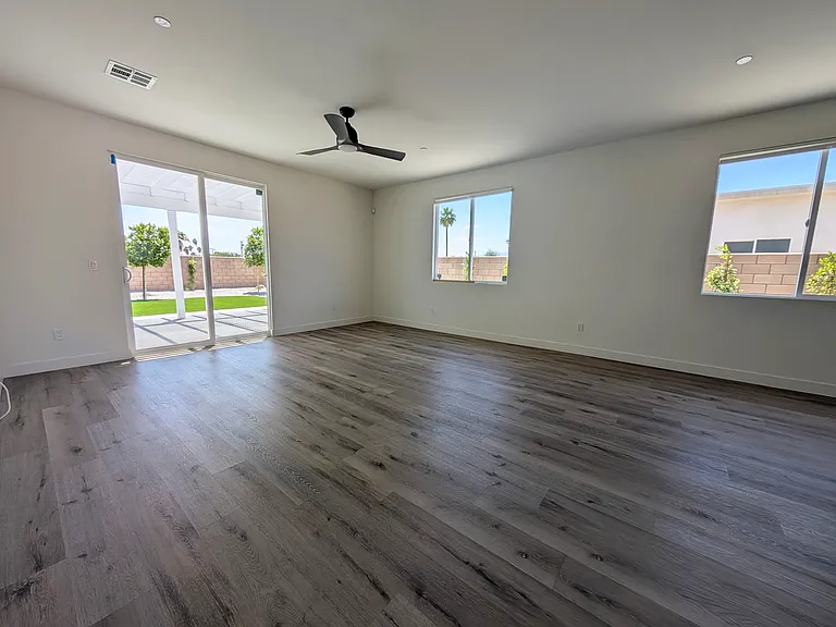 Large open concept living room with views to the full landscaping backyard.