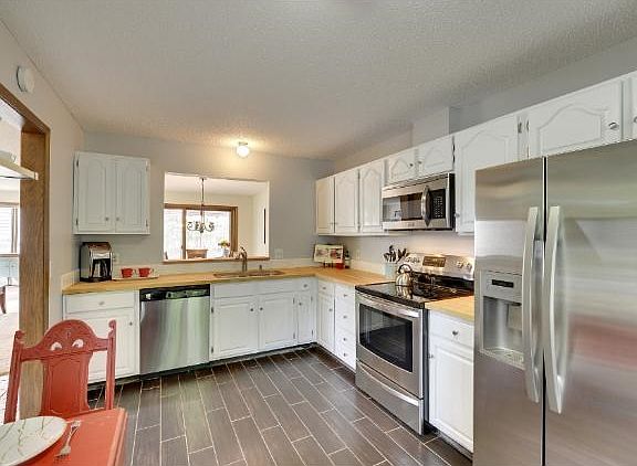 Large and open kitchen with new flooring, updated cabinets, and newer appliances!