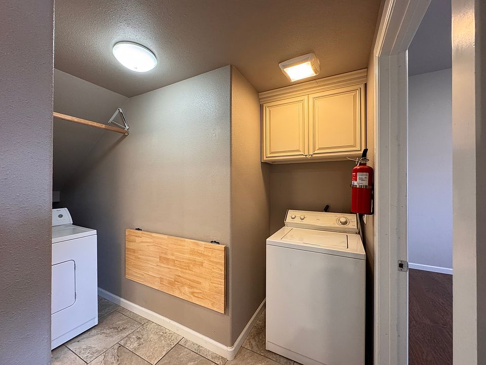 Washer, dryer and folding table in the laundry nook on the main floor beside entrance to bedroom #1.