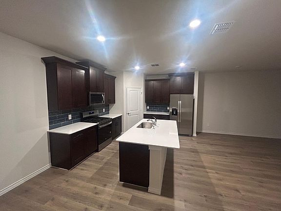 Kitchen with stainless steel appliances and refrigerator