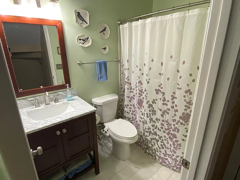 Guest bathroom upstairs with tiled floor, marble counter, and full tile bathtub/shower.