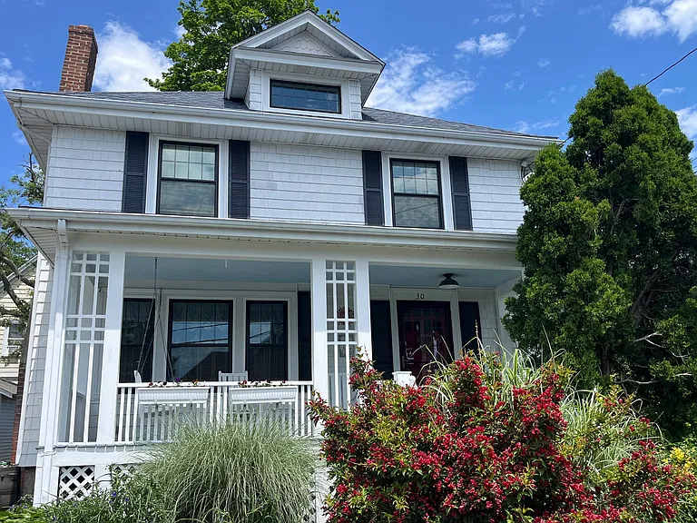 Front view of house. Porch includes rockers and swing.
