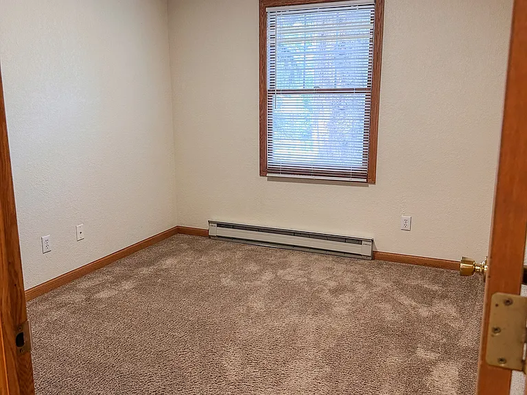 Comfortable primary bedroom with room for a queen bed, desk, and additional furniture.