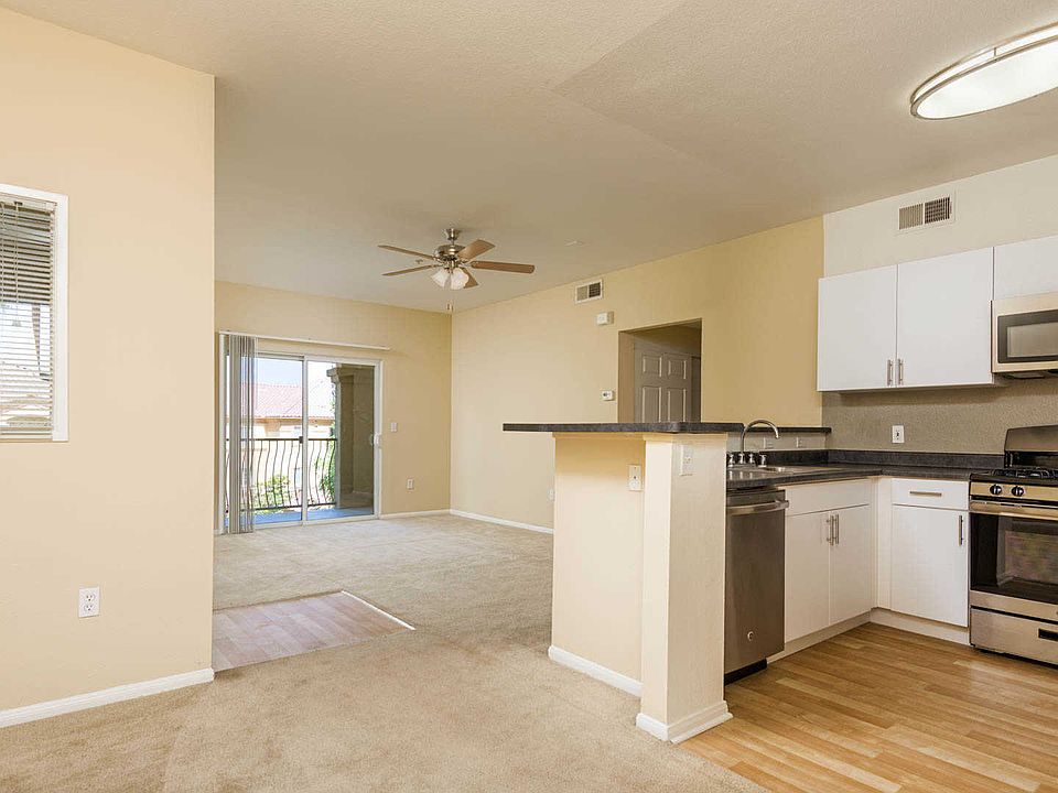 Kitchen and Carpeted Living Room with Balcony