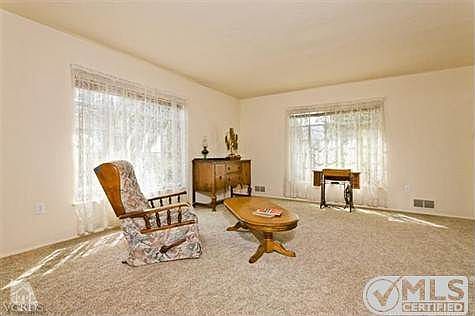 Living room has high ceilings and luxurious carpet