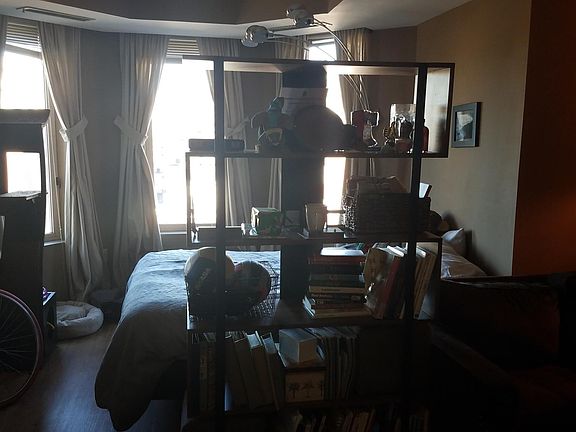 center of studio; bed straight ahead, living room nook off to right, desk/office area to left