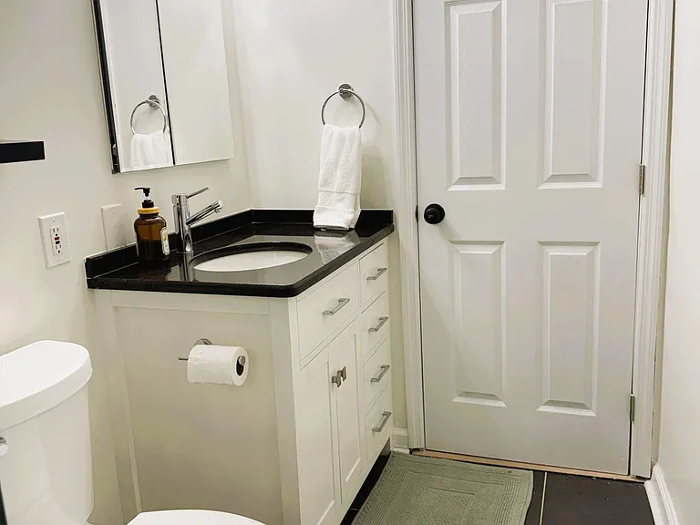 Well-kept bathroom with a single-sink vanity, mirrored medicine cabinet, and tiled flooring for easy maintenance.