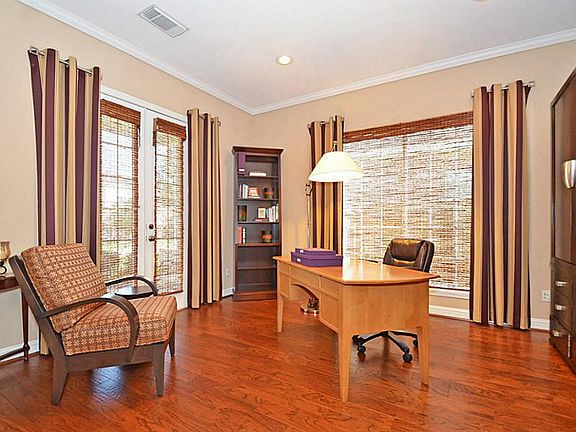 Custom blinds on window and door in the large hardwood floor study.
