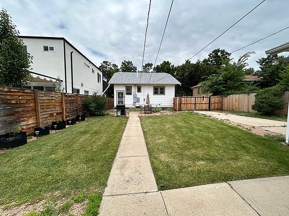 Back yard grassy area and gated driveway area