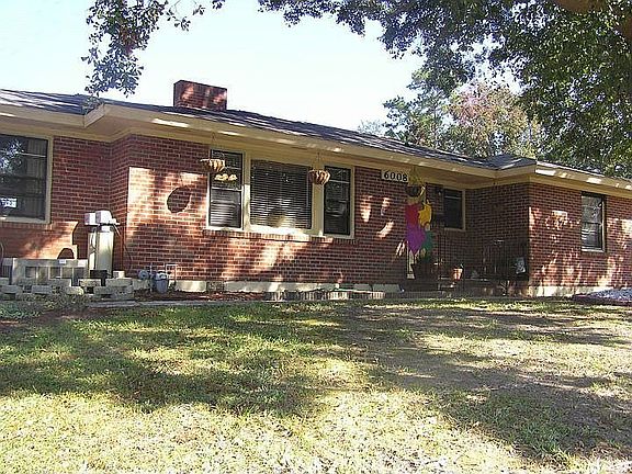 This low-maintenance brick home  sits up high on a large lot.