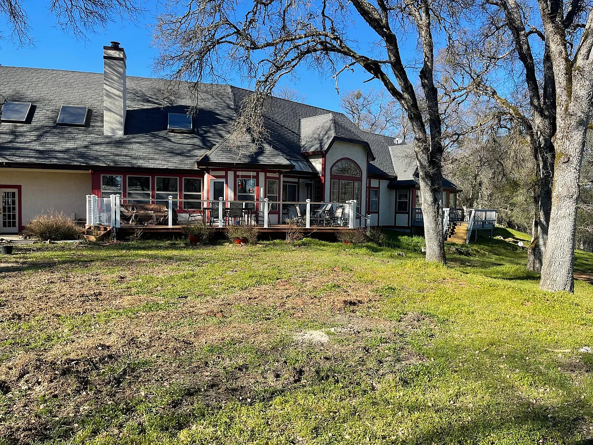 Back of house with many views of the majestic rolling hills on 30 acres and large trex deck with lounge chairs and an outdoor table that seats 6 - 21039 Brewer Rd