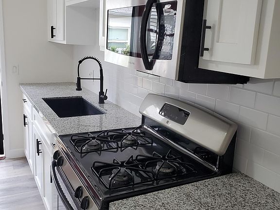 Newly Renovated kitchen with granite countertops, stainless appliances , and farmhouse sink