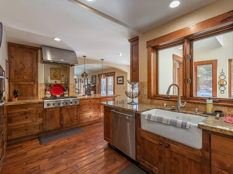 Large kitchen with oven, microwave, dishwasher, large bottom freezer LG refrigerator, and Farm sink with view of large fenced yard