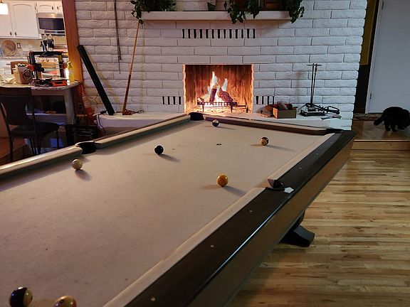 Living room with fireplace and pool table