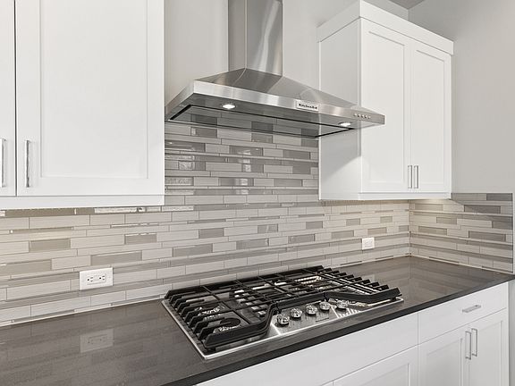 Gas cooking, stainless steel hood, full height tile backsplash