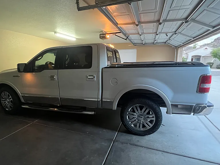 2.5 car garage with extra refrigerator/freezer, sink, large window for natural light sometimes used as a workout area with weight equipment, back door out to side yard and trash cans and rv gate