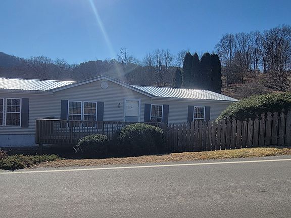 Small deck on front of house. Round parking area above house for access to deck and front door.