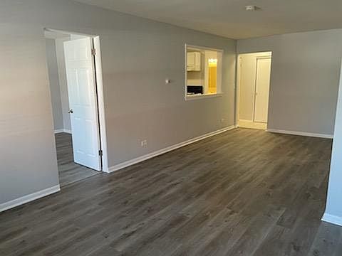 View of living & dining areas. Door on the left enters to bedroom. 1/2 wall opening leads into kitchen.
