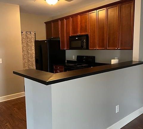 Kitchen with ample cabinet space and pantry adjacent for easy access. Condo comes with stove/oven, new microwave, dishwasher, and refrigerator.