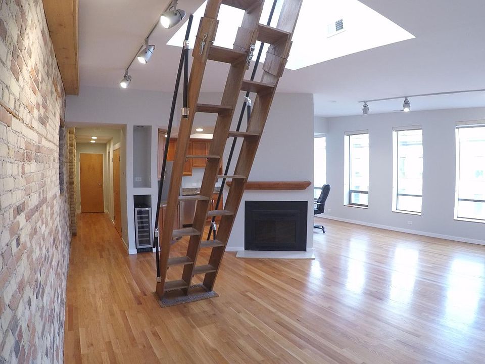 View of living room and stairs to private roof deck