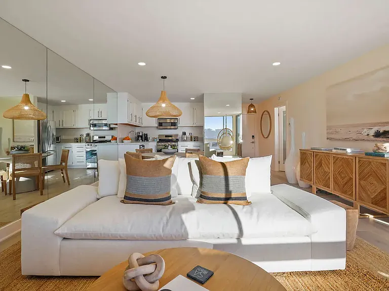 Open-plan living and kitchen area with modern furnishings, perfect for a relaxed beachside experience.