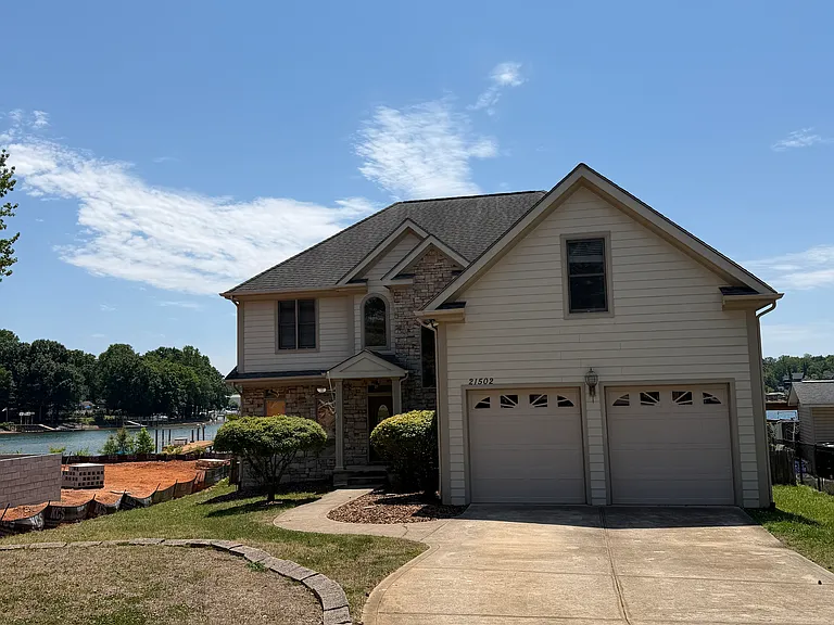 Classic lakefront home with a two-car garage and quiet curb appeal_pull into the driveway and leave the noise behind, with the water just steps from your front yard.
