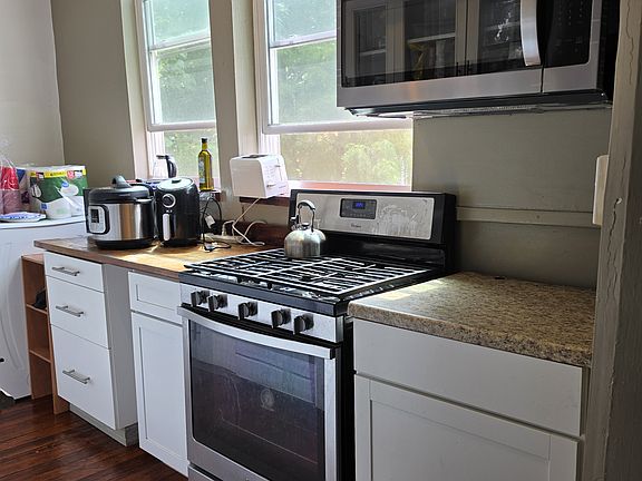 Bright kitchen with gas range and microwave