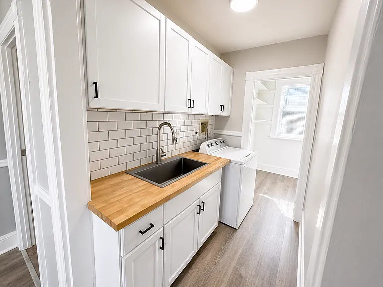 Refreshed kitchen with new fixtures, cabinets, subway tile backsplash.