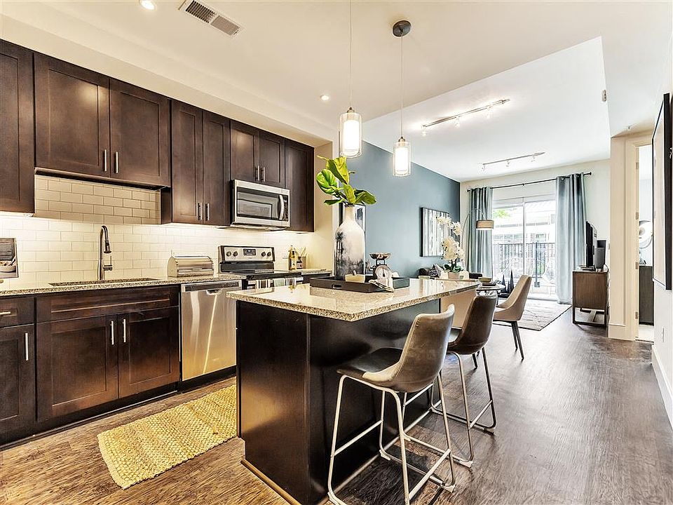 Large kitchen island with hardwood flooring and dark cabinets