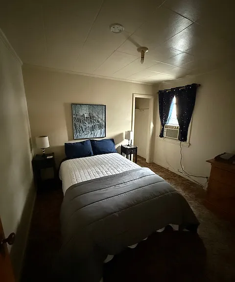 Bedroom 1- double bed with room darkening curtains, closet, dresser, nightstands, lamps.