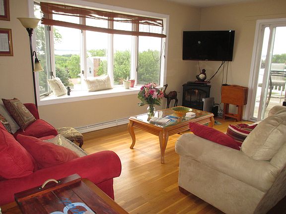 Upstairs living room with open floor plan to the kitchen and dining room area. Bay window with panoramic waterfront view