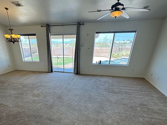 From the front door, you're welcomed by a wall of windows offering a stunning view of the backyard oasis, which features a covered patio and a beautiful swimming pool_perfect for relaxing or entertaining.
