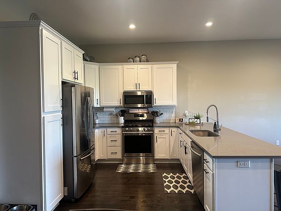 large kitchen area with pantry and garbage/recycle pull out drawer