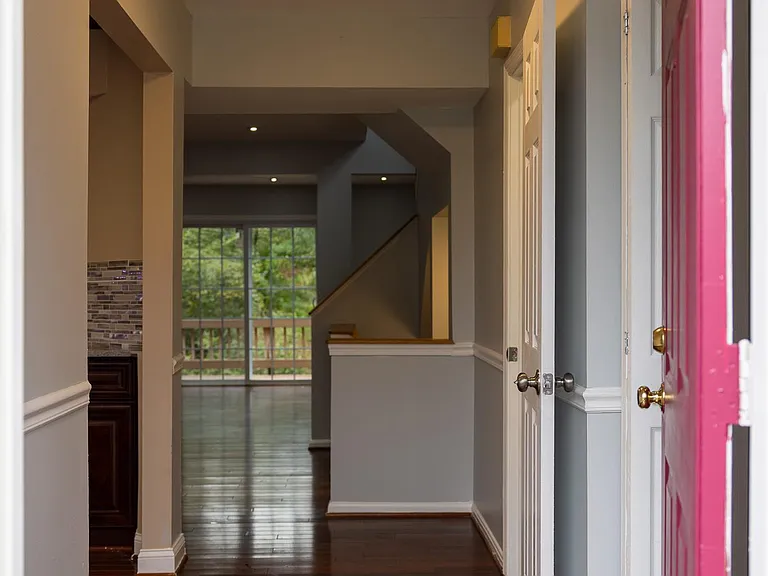 Foyer with shoe rack and coat closet on the right and kitchen on the left.