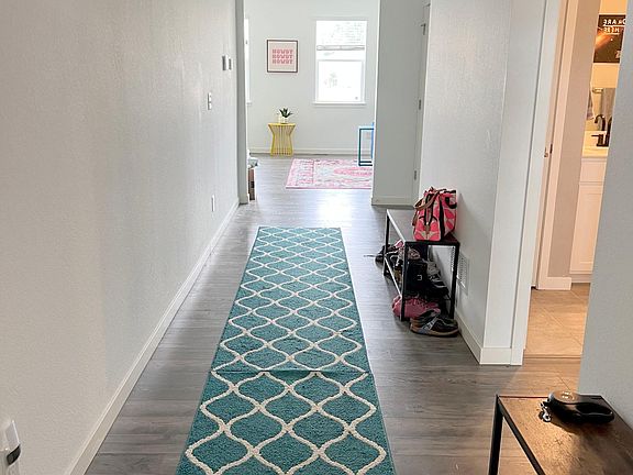 Entry way from from door. First floor full bathroom and a bedroom with a walk-in closet are to the right of the front door.