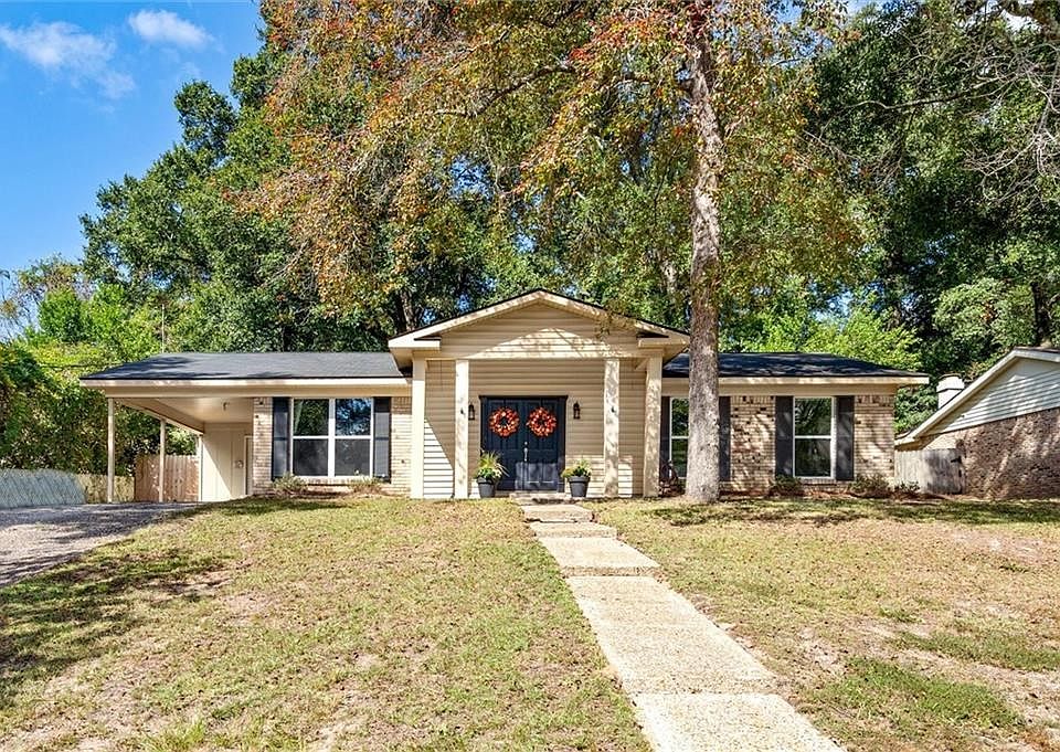 Ranch-style home with a carport and a front lawn