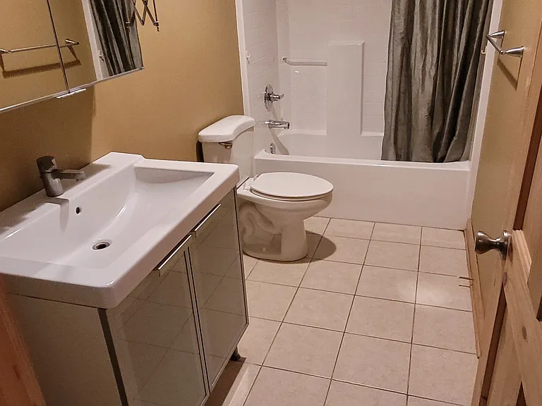 Guest Bath with Tub and Shower, Mirror with Medicine Cabinet above Sink Vanity, Makeup Mirror, and Bath/Toiletries Closet (not pictured).