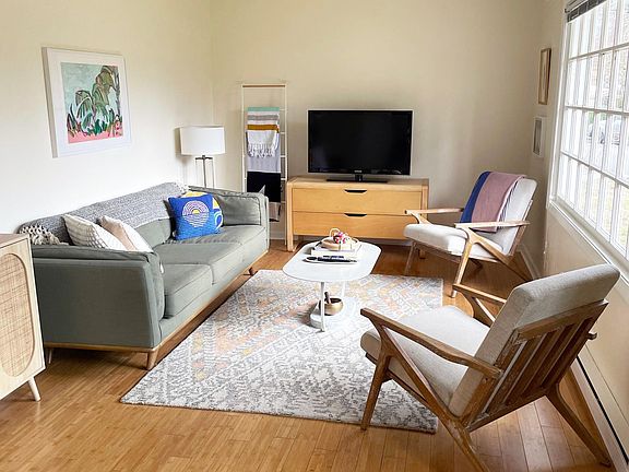 The living room is cozy and eclectic, with lots of light!