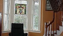 Living room with elegant, original windows and stairway