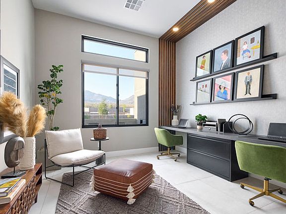 A cozy and modern home office space with a comfortable chair, a desk with a computer, and various de