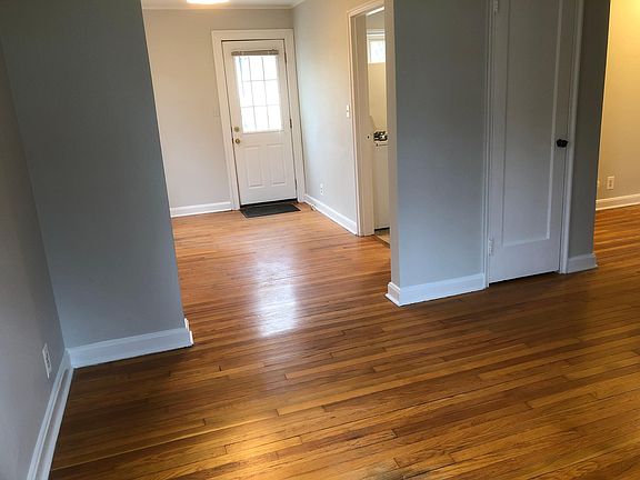 Living room into dining room with rear entrance door.