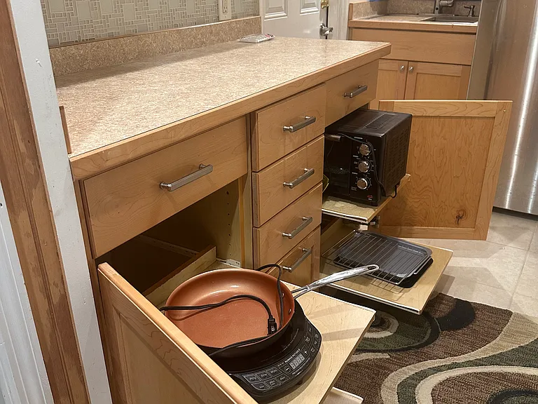 Pullout shelves in base cabinets and 6 drawers - all filled with tools, flatware, cups bowls & plates, pits & pans, its all here