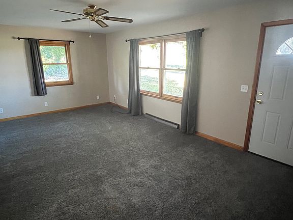 Living room with new carpeting and ceiling fan.