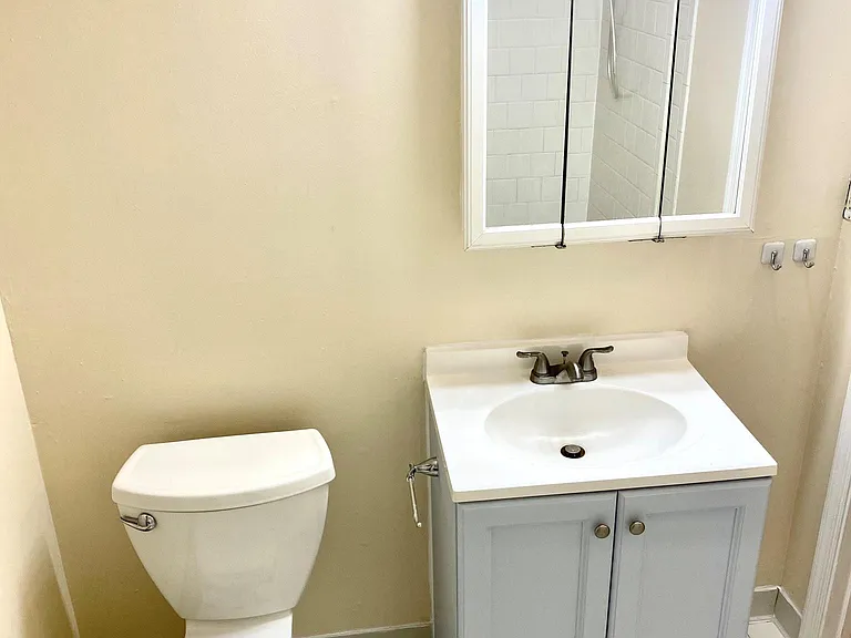 Spacious bright bathroom with shower/tub and built-in shelf space for toiletries and towels